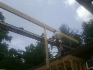 Carpenter setting a ridge beam over a new addition frame — Ice Dam Removal by Roofing Brothers in Wingdale