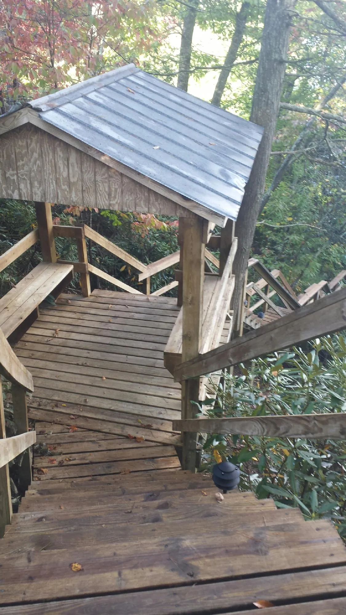 Metal roofed shelter over wooden steps on a wooded walkway — Skylight Repair & Installation work by our crew in Wingdale
